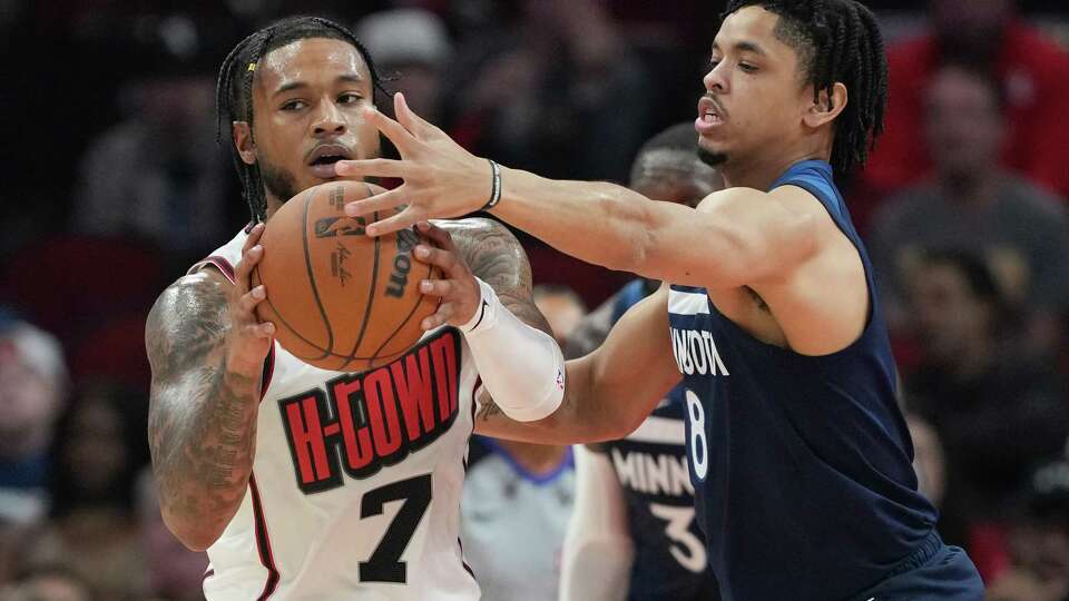 Houston Rockets forward Cam Whitmore (7) holds onto the ball as Minnesota Timberwolves forward Josh Minott (8) applies pressure in the first half of game action at the Toyota Center on Friday, Dec. 27, 2024 in Houston.