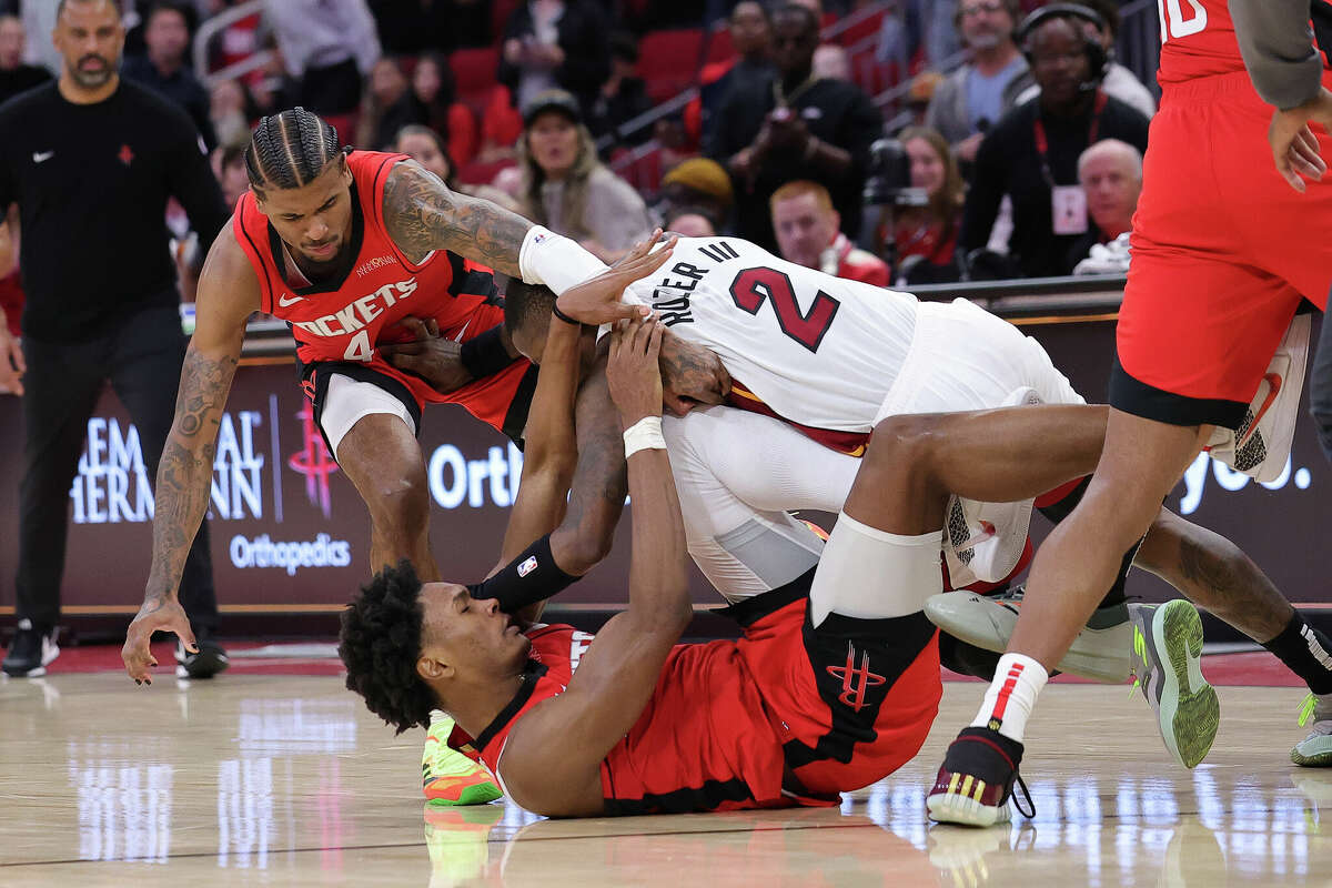 Jalen Green and Amen Thompson of the Houston Rockets fight with Terry Rozier of the Miami Heat during the second half at Toyota Center on December 29, 2024 in Houston, Texas.