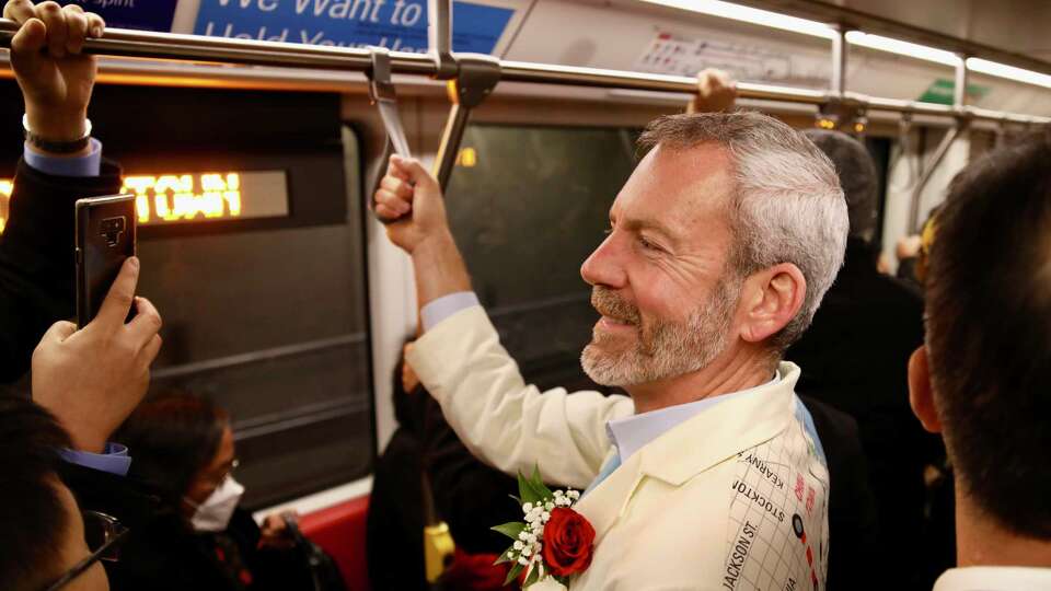 Jeffrey Tumlin, Director of Transportation, San Francisco Municipal Transportation Agency, dons a transit suit while riding on the new subway line at the Muni Chinatown-Rose Pak Station on Saturday, November 19, 2022, in San Francisco, Calif.