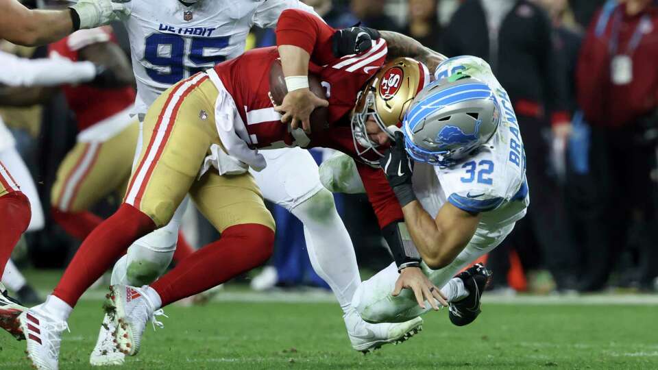 San Francisco 49ers quarterback Brock Purdy (13) is tackled by Detroit Lions safety Brian Branch (32) during the second half of an NFL football game Monday, Dec. 30, 2024, in Santa Clara, Calif. (AP Photo/Jed Jacobsohn)