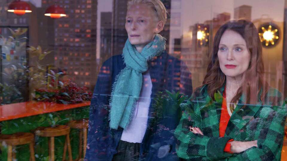 This image released by Sony Pictures Classics shows Julianne Moore, right, and Tilda Swinton in a scene from 'The Room Next Door.' (Sony Pictures Classics via AP)