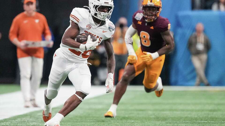 Texas running back Quintrevion Wisner (26) runs past Arizona State linebacker Jordan Crook (8) for a 43-yard gain during the first half of an NCAA college football playoff quarterfinal game at the Peach Bowl on Wednesday, Jan. 1, 2025, in Atlanta.