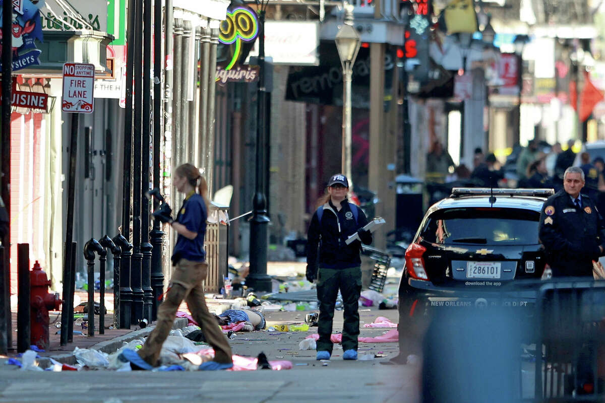 NEW ORLEANS, LOUISIANA - JANUARY 1: (EDITOR'S NOTE: Image depicts death.) A member of the FBI's Evidence Response Team take photographs near a pair of bodies on Bourbon Street after at least ten people were killed when a driver drove into the crowd in the early morning hours of New Year's Day on January 1, 2025 in New Orleans, Louisiana. Dozens more were injured after a suspect in a rented pickup truck allegedly drove around barricades and through a crowd of New Year's revelers on Bourbon Street. The suspect then got out of the car opened fire on police officers and was subsequently killed by law enforcement. (Photo by Michael DeMocker/Getty Images)