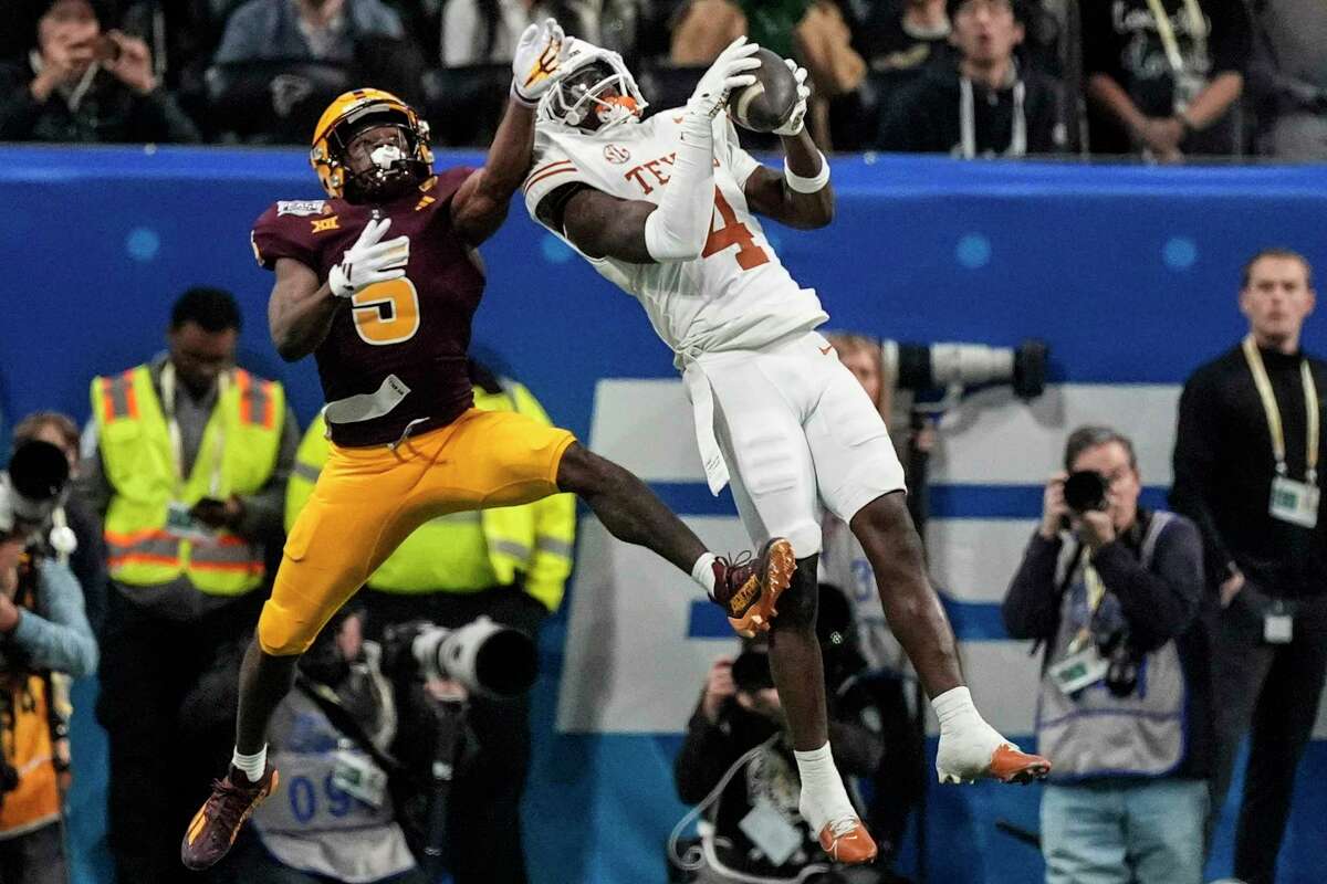 Texas defensive back Andrew Mukuba (4) intercepts a pass intended for Arizona State wide receiver Melquan Stovall (5) during overtime in the quarterfinals of a College Football Playoff game, Wednesday, Jan. 1, 2025, in Atlanta. Texas won 39-31 in two overtime periods.