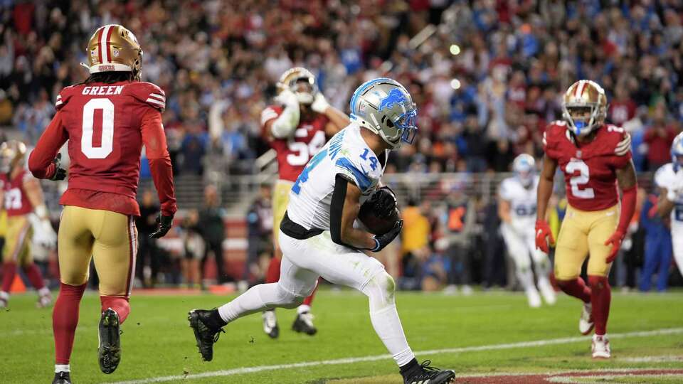 Detroit Lions wide receiver Amon-Ra St. Brown (14) catches a touchdown during the second half of an NFL football game against the San Francisco 49ers, Monday, Dec. 30, 2024, in Santa Clara, Calif. (AP Photo/Godofredo A. Vásquez)