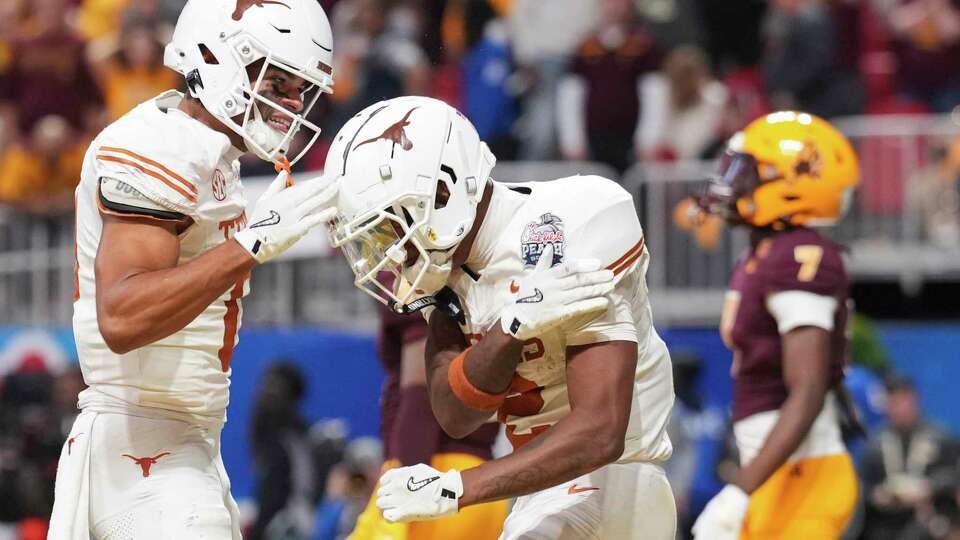 Texas wide receiver DeAndre Moore Jr., left, celebrates with wide receiver Matthew Golden after his a 28-yard touchdown catch in the first overtime period of the Peach Bowl during a NCAA college football playoff quarterfinal game on Wednesday, Jan. 1, 2025, in Atlanta.