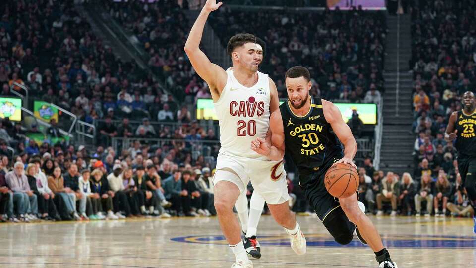 Golden State Warriors guard Stephen Curry, right, moves the ball while defended by Cleveland Cavaliers forward Georges Niang (20) during the first half an NBA basketball game Monday, Dec. 30, 2024, in San Francisco. (AP Photo/Kavin Mistry)