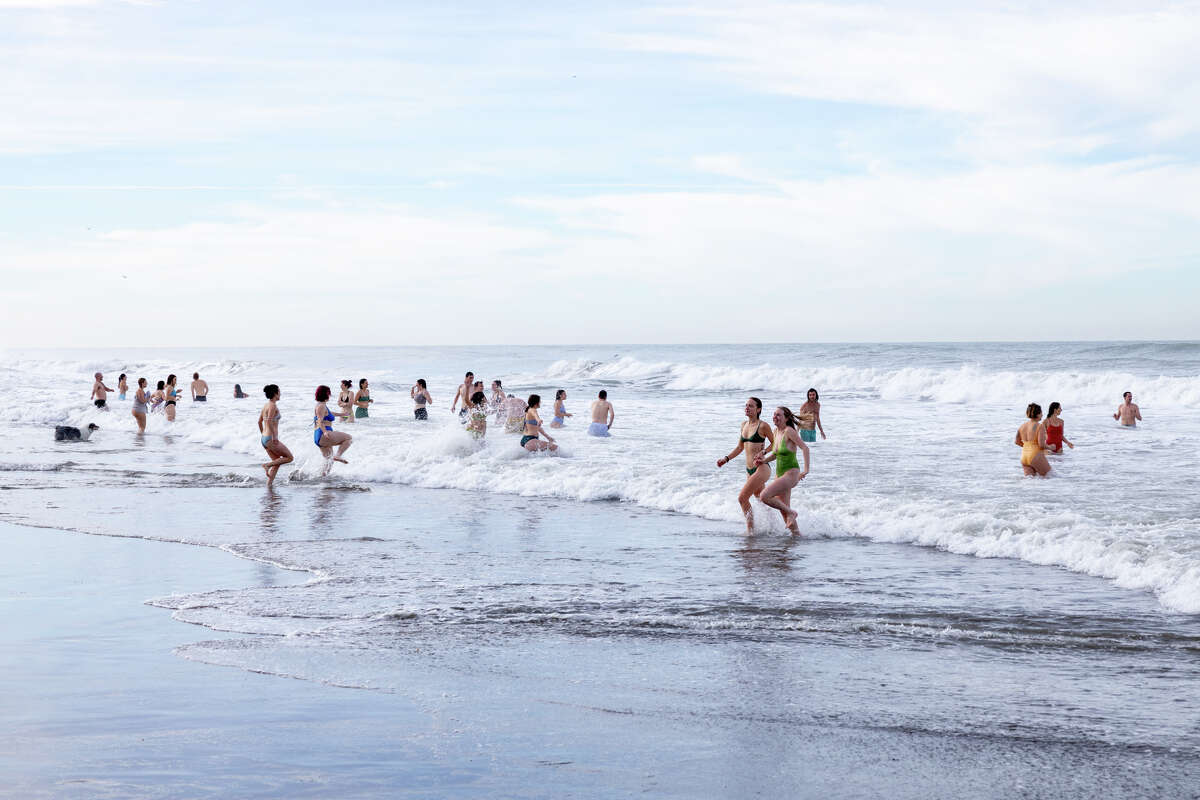 Participants in the 2025 Strip N Dip at Ocean Beach brave the icy water on New Years Day, Jan. 1, 2025.