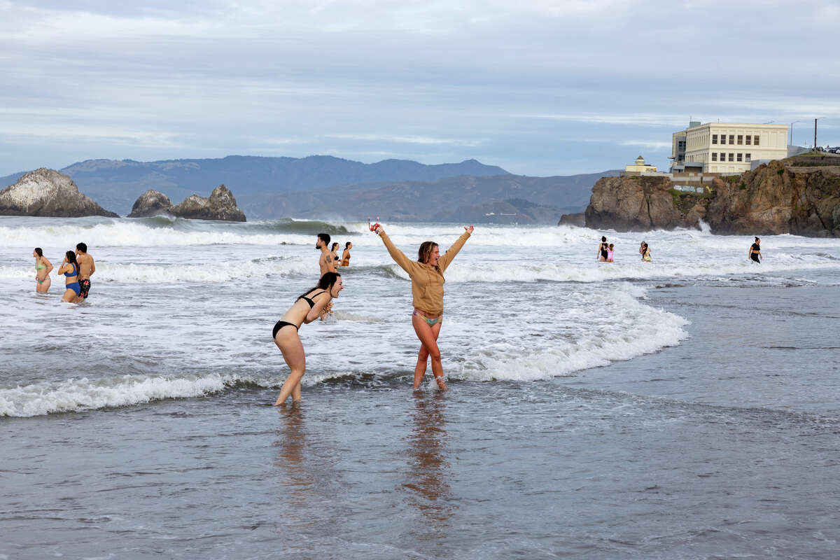 Participants in the 2025 Strip N Dip at Ocean Beach brave the icy water on New Years Day, Jan. 1, 2025.