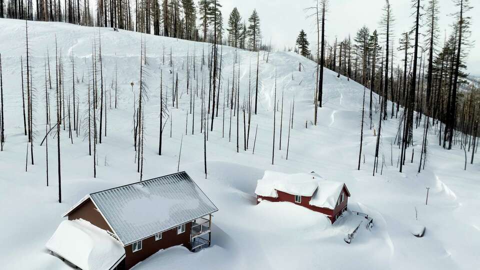 Snow surrounds homes near Sierra at Tahoe in Twin Bridges, Calif., on Monday, March 4, 2024.