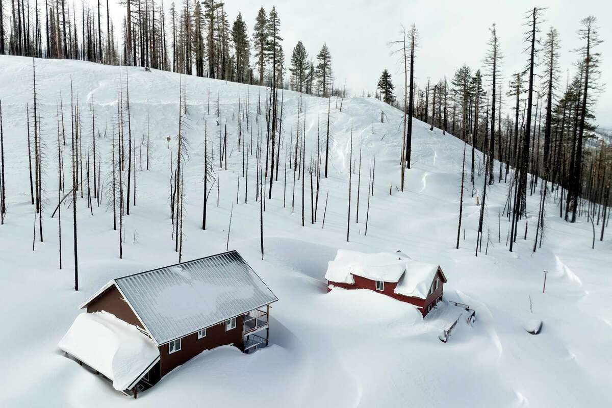 Snow surrounds homes near Sierra at Tahoe in Twin Bridges, Calif., on Monday, March 4, 2024.