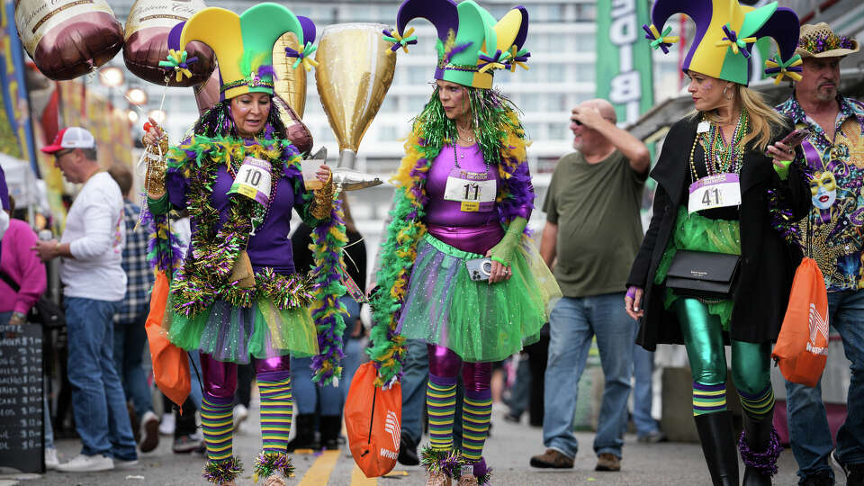 Runners from the Jolly Jester Jaunt 5K peruse food stalls before parades start Saturday, Feb. 3, 2024, in the Strand district in Galveston.