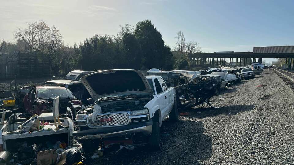 A stretch of land alongside railroad tracks in East Oakland has become an illegal junkyard for abandoned vehicles. Authorities are struggling to clean up the area and prevent further dumping.