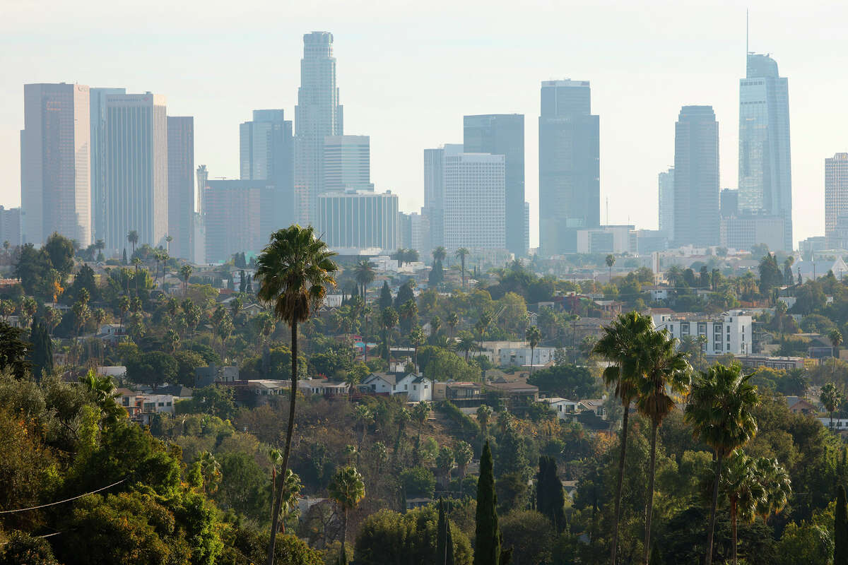 A view of palm trees and the Los Angeles skyline is seen on December 26, 2024 in Los Angeles, Calif.