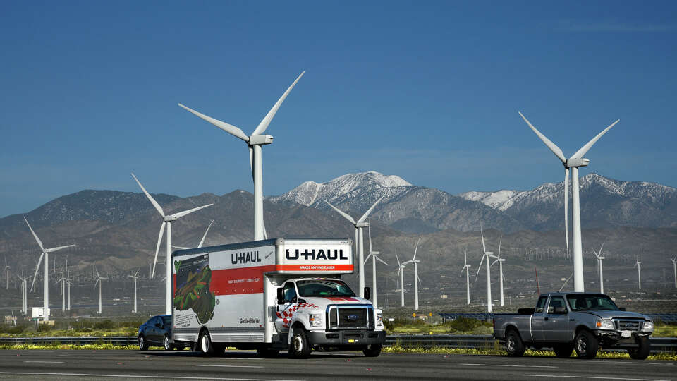 PALM SPRINGS, CALIFORNIA - FEBRUARY 27, 2019: A U-Haul truck and other vehicles travel along Interstate 10 as wind turbines generate electricity at the San Gorgonio Pass Wind Farm near Palm Springs, California. Located in the windy gap between Southern California's two highest mountains, the facility is one of three major wind farms in California. (Photo by Robert Alexander/Getty Images)