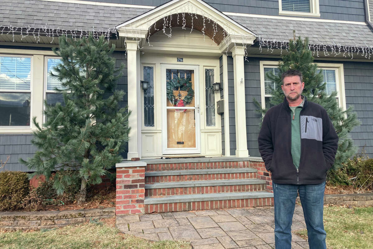 Chris Caulfield stands outside his home on Harmon Street in Hamden, Conn., on Friday, Jan. 3, 2025. Chris Caulfield said he and his wife, Tiffany Caulfield, are considering moving out of Hamden after their home's assessed value skyrocketed following a town-wide revaluation this year.