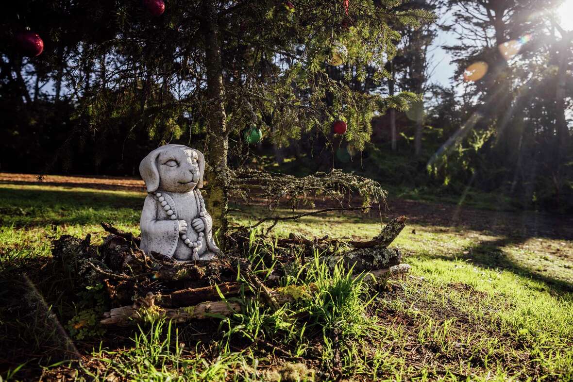 A statue is seen beneath a small decorated tree at Golden Gate Heights Park in San Francisco, Thursday, Jan. 2, 2025.