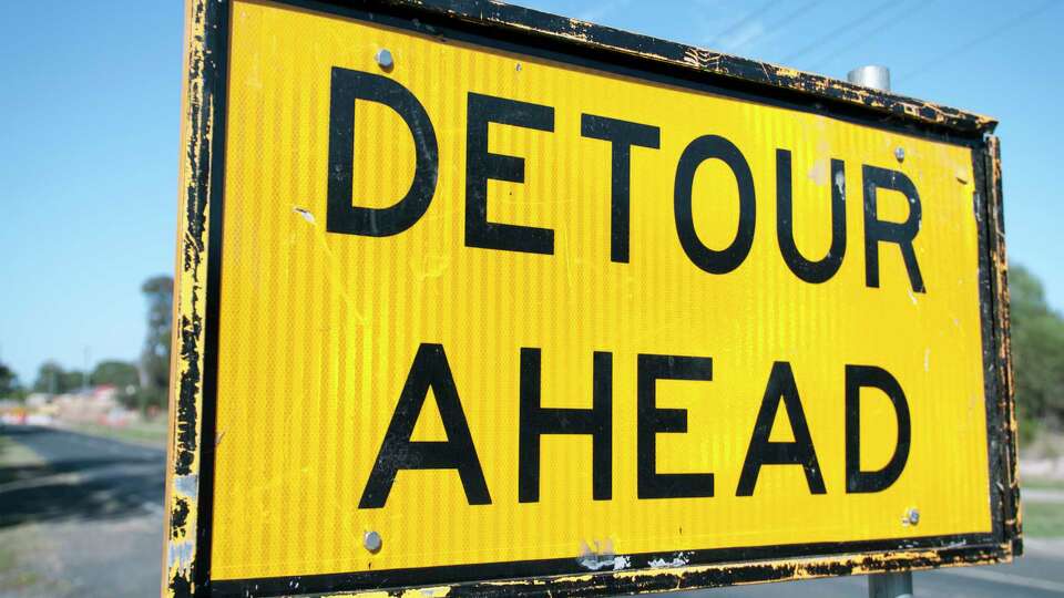 A detour sign on the road, due to roadwork ahead.