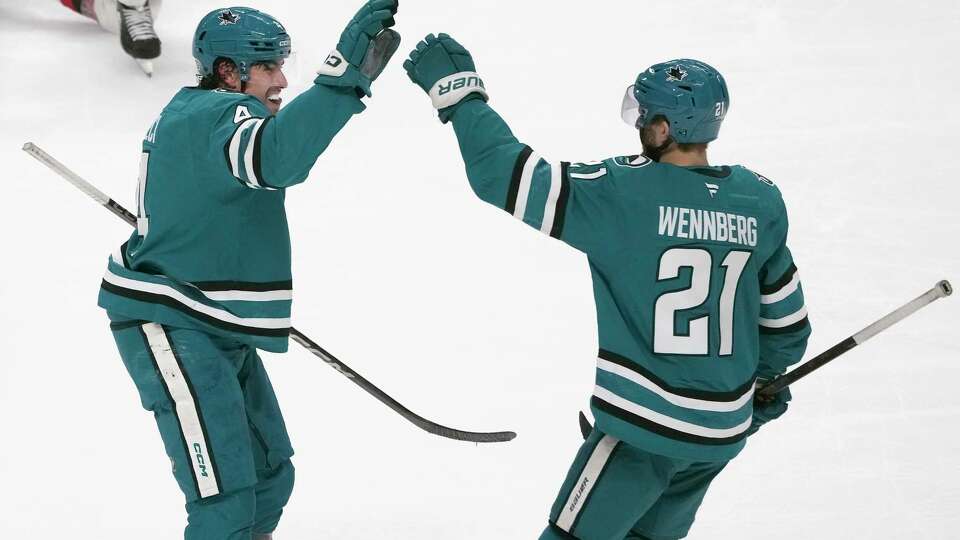 San Jose Sharks defenseman Cody Ceci, left, is congratulated by center Alexander Wennberg (21) after scoring against the New Jersey Devils during the third period of an NHL hockey game in San Jose, Calif., Saturday, Jan. 4, 2025.