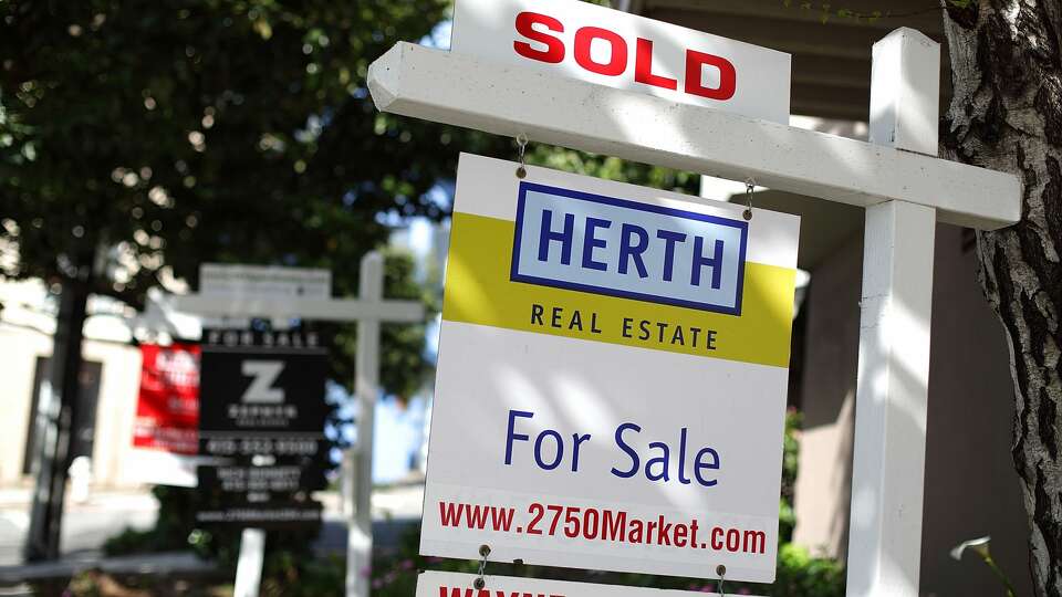 In this file photo, real estate signs are posted in front of homes for sale in San Francisco.