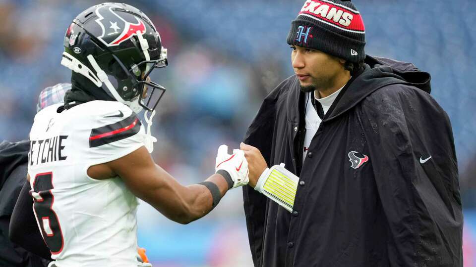 Houston Texans quarterback C.J. Stroud, right, gives a fist-bump to wide receiver John Metchie III during the second half of an NFL football game Sunday, Jan. 5, 2025, in Nashville, Tenn.