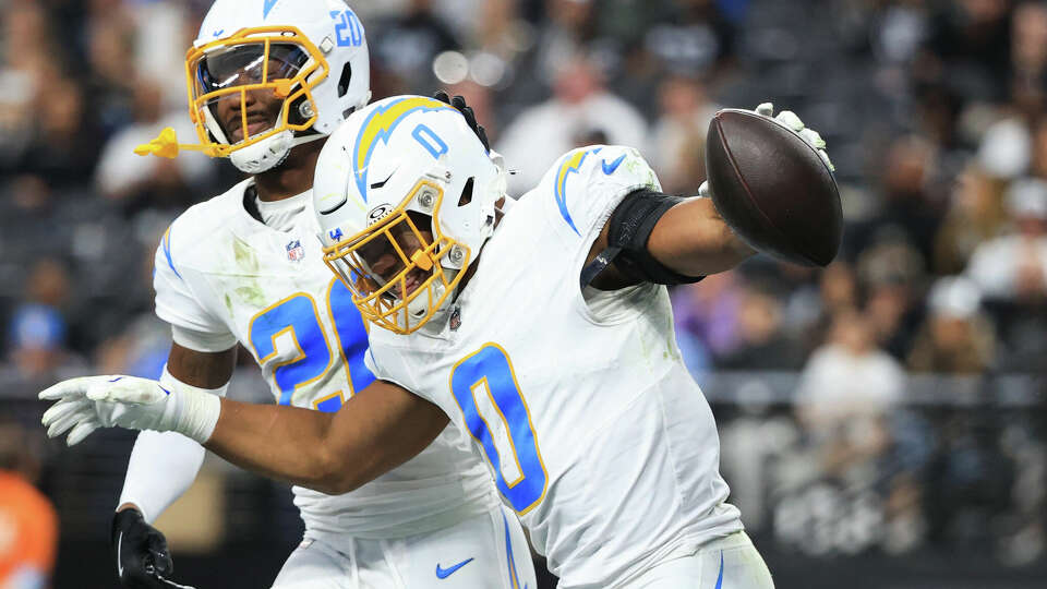 Daiyan Henley (0) of the Los Angeles Chargers celebrates with teammate Cam Hart (20)after an interception against the Las Vegas Raiders during the second quarter at Allegiant Stadium on January 05, 2025 in Las Vegas, Nevada.