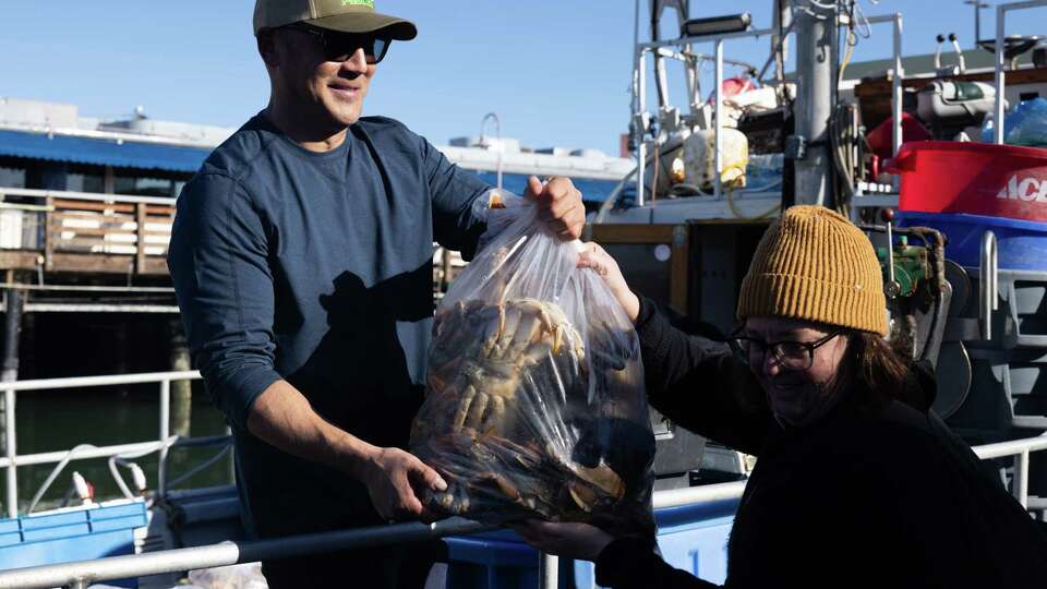 Matt Juanes sells crabs to Sarah Davis during an off-the-boat crab sale at Fisherman’s Wharf in San Francisco on Sunday, Jan. 5, 2025. Sunday was the start of the Dungeness crab season in San Francisco.