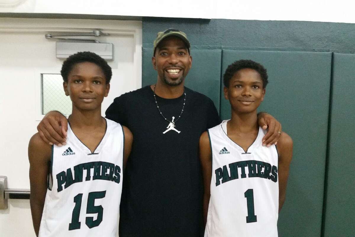 Amen and Ausar Thompson pose with their dad, Troy, after a childhood tournament. 