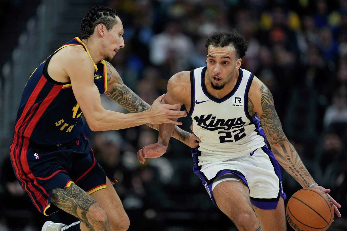 Sacramento Kings guard Devin Carter, right, moves the ball while defended by Golden State Warriors forward Lindy Waters III, left, during the first half of an NBA basketball game Sunday, Jan. 5, 2025, in San Francisco.