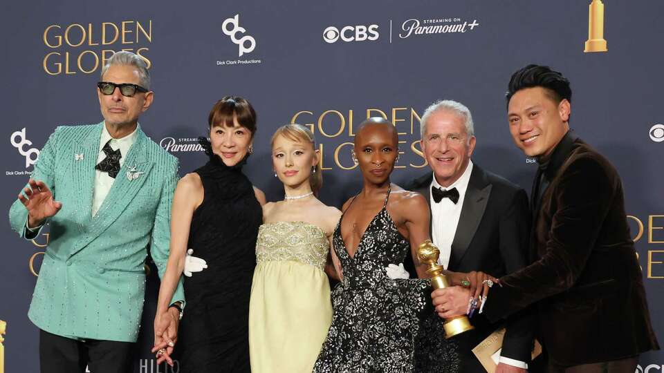 BEVERLY HILLS, CALIFORNIA - JANUARY 05: (L-R) Jeff Goldblum, Michelle Yeoh, Ariana Grande, Cynthia Erivo, Marc Platt, and Jon M. Chu, winners of the Cinematic and Box Office Achievement award for “Wicked,” pose in the press room during the 82nd Annual Golden Globe Award at The Beverly Hilton on January 05, 2025 in Beverly Hills, California.