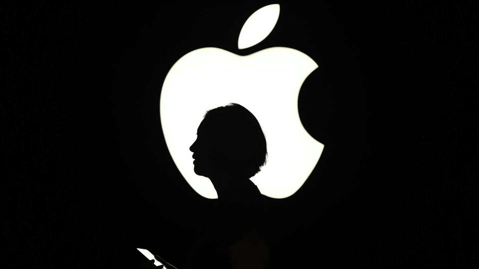 (FILES) This file photo taken on September 09, 2015 shows a woman walking by an Apple logo during a media event in San Francisco, California. Apple said June 13, 2016 it was opening up its Siri digital assistant to outside applications, stepping up its artificial intelligence efforts to compete against rival services from Amazon, Google and Microsoft.The new feature will enable iPhone users to connect with non-Apple services to send messages, make payments and search photos, for example. / AFP PHOTO / Josh EdelsonJOSH EDELSON/AFP/Getty Images