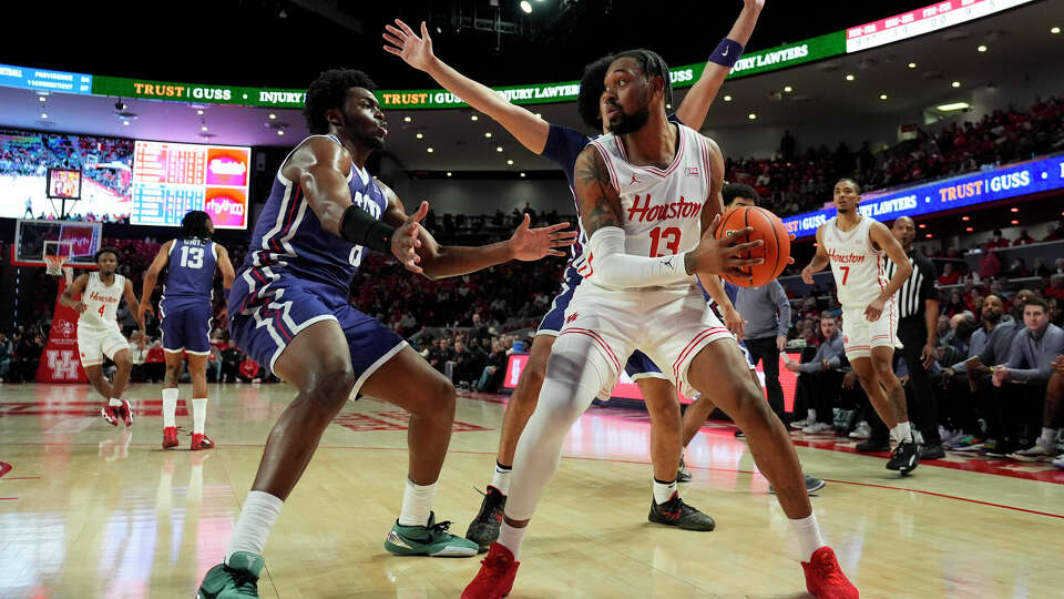 TCU center Ernest Udeh Jr., left, and forward David Punch defend against Houston forward J'Wan Roberts (13) during the first half of an NCAA college basketball game in Houston, Monday, Jan. 6, 2025. (AP Photo/Ashley Landis)