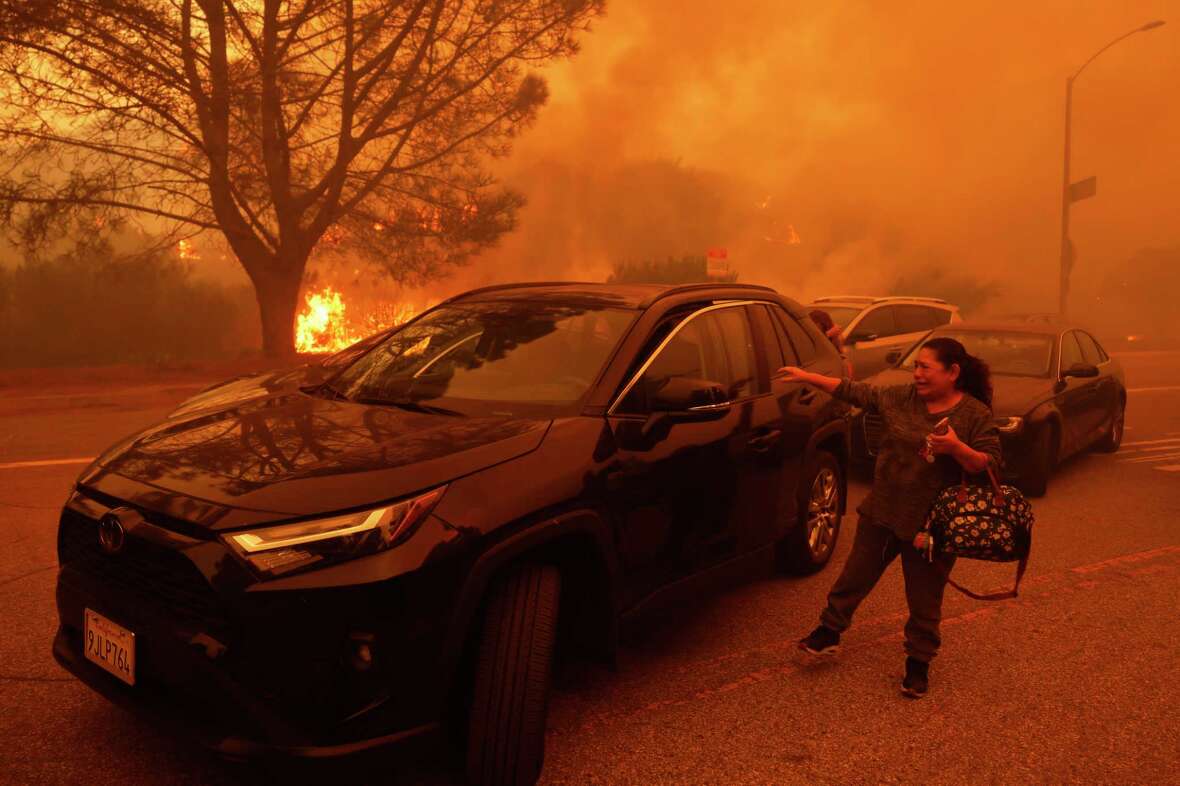 A woman cries as the Palisades Fire advances in the Pacific Palisades neighborhood of Los Angeles Tuesday, Jan. 7, 2025.