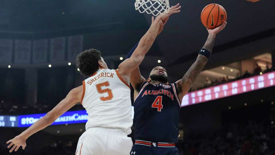 Auburn forward Johni Broome (4) shoots past Texas forward Kadin Shedrick (5) during the first half of an NCAA college basketball game in Austin, Texas, Tuesday, Jan. 7, 2025. (AP Photo/Eric Gay)