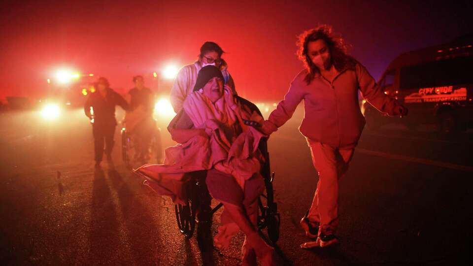 Residents of a senior center are evacuated as the Eaton Fire approaches Tuesday, Jan. 7, 2025 in Altadena, Calif. (AP Photo/Ethan Swope)