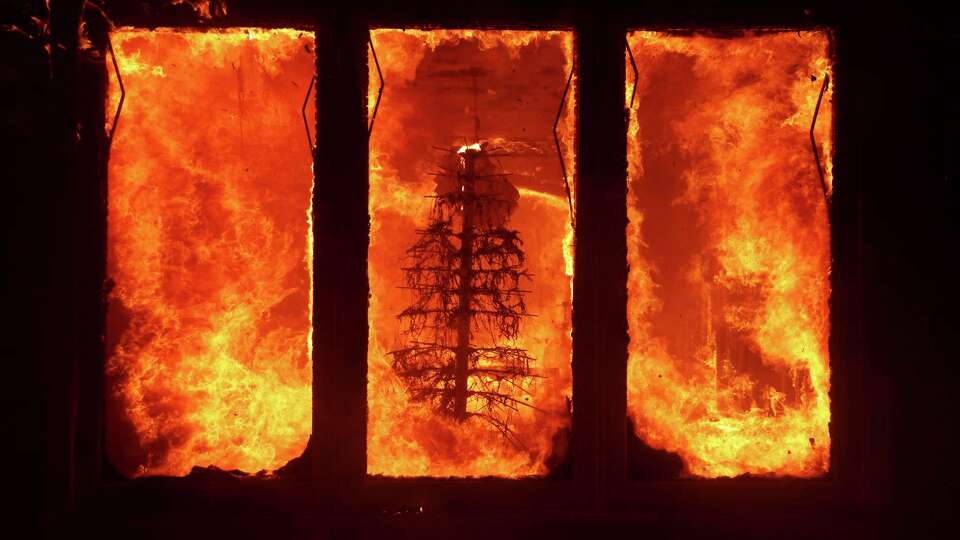 The Palisades Fire burns a Christmas tree inside a residence in the Pacific Palisades neighborhood of Los Angeles, Tuesday, Jan. 7, 2025.