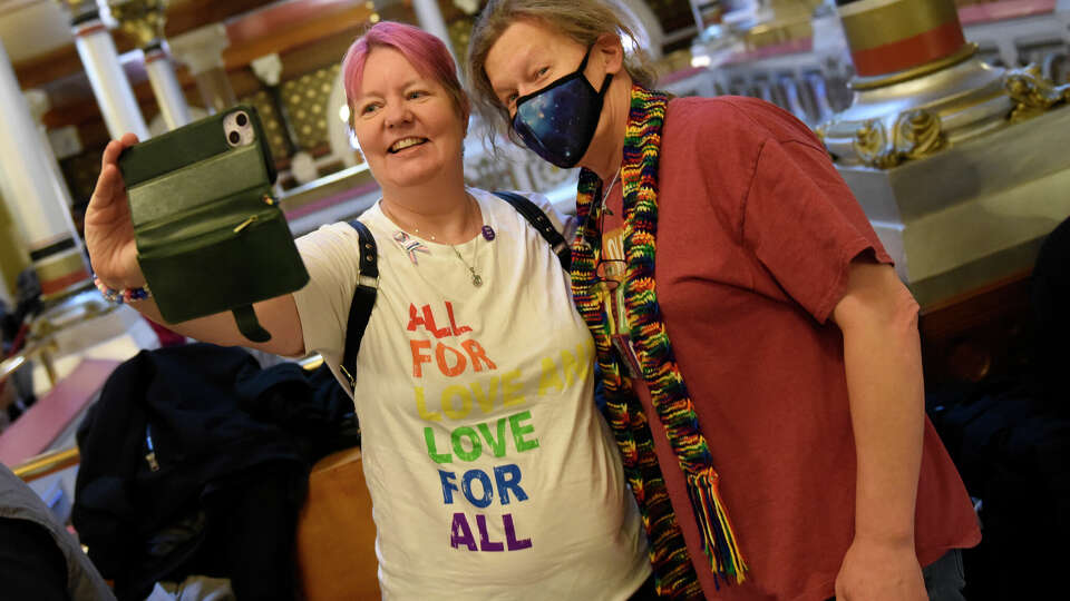 Lynn Hettrick, left, of Durham, and Clare McCarthy, of East Haddam, take a selfie together while showing support for the LGBTQ Justice & Opportunity Network on the first day of legislation of the new year at the Connecticut State Capitol in Hartford, Conn. on Jan. 8, 2025. LGBT+ advocates rallied for more state protections and access to care ahead of the upcoming Trump presidency.