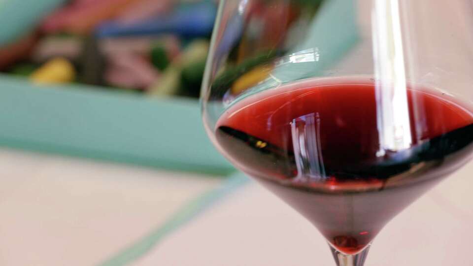 A wine glass on the table next to colored chalk crayons for drawing on glass plates during her 'Make-A-Plate' Workshop at Annieglass in Watsonville, Calif., Sunday, November 12, 2017. The store is run by Annie Morhauser, whose glass work is featured in high-end retailers like Neiman Marcus.