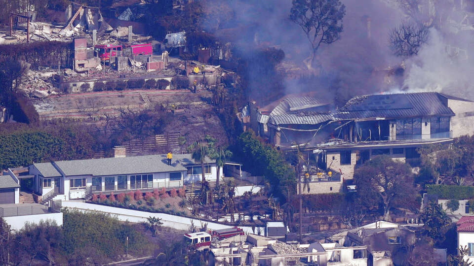 Firefighters protect what is left of homes from the Palisades Fire, Thursday, Jan. 9, 2025, in Malibu, Calif. 