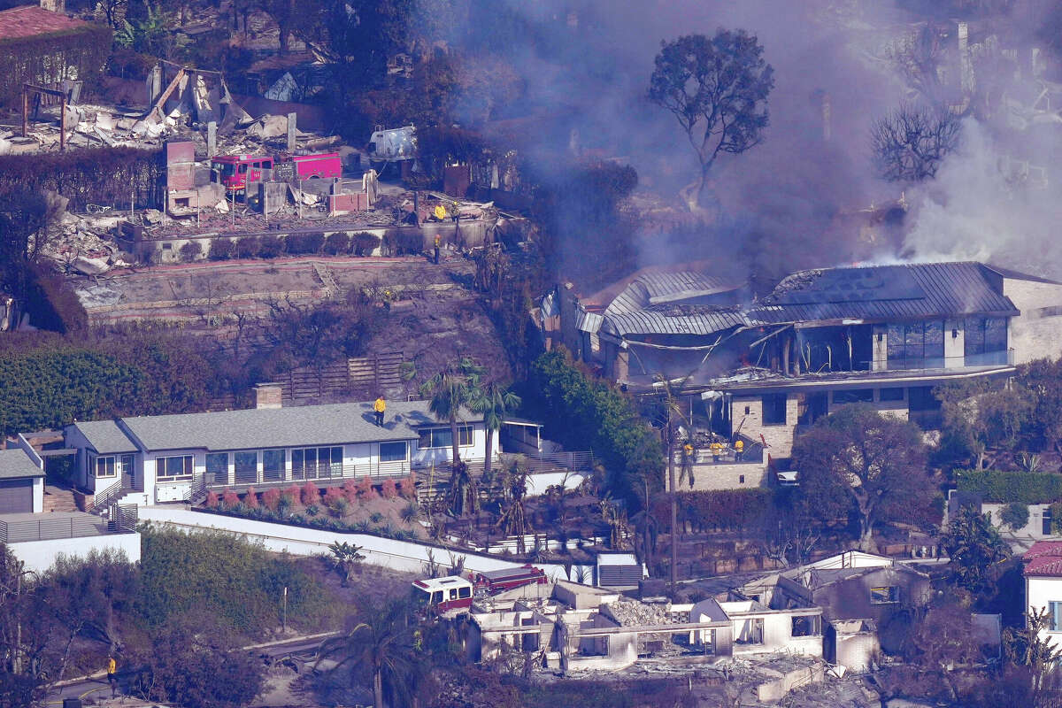 Firefighters work to protect remaining homes from the Palisades Fire on Thursday. Many homes in the area are on the FAIR Plan.