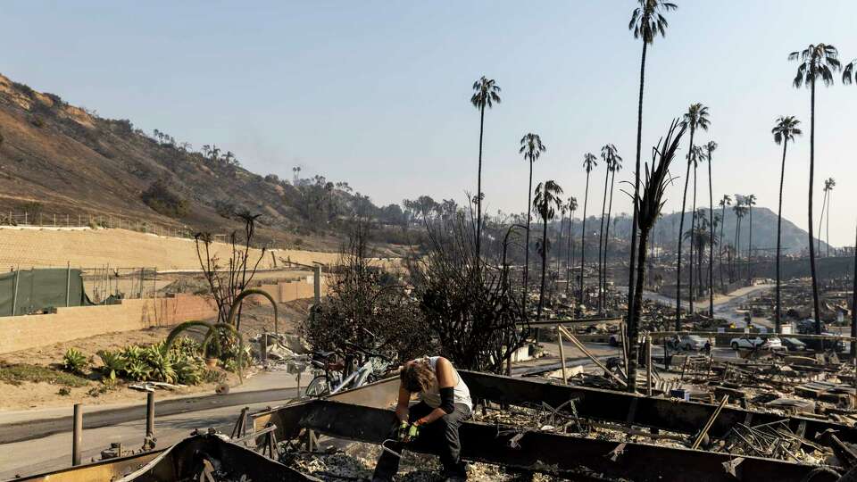 Roger Cohn pauses as he looks for items amongst his girlfriend Lisa Anderson’s home destroyed by the Palisades Fire in Pacific Palisades, Calif., Thursday, Jan. 9, 2025.