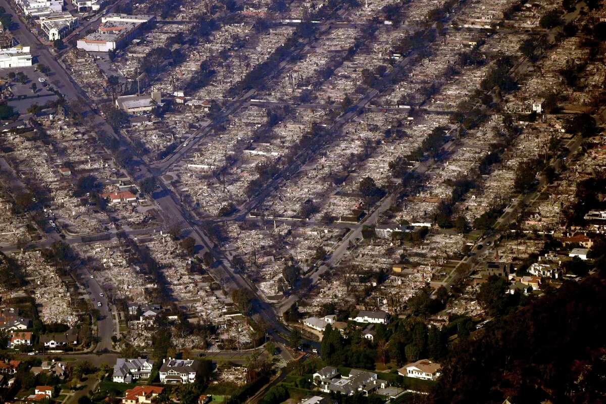 Homes are seen burned while a few still stand, Thursday, Jan. 9, 2025, in the Pacific Palisades section of Los Angeles.