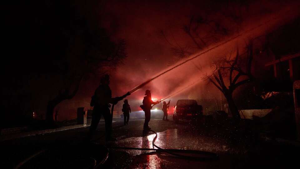 LOS ANGELES, CALIFORNIA - JANUARY 8: Firefighters battle flames from the Palisades Fire on January 8, 2025 in the Pacific Palisades neighborhood of Los Angeles, California.