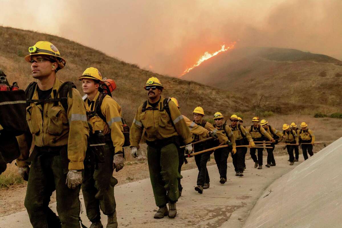 Fire crews walk as they battle the Kenneth Fire in the West Hills section of Los Angeles, Thursday, Jan. 9, 2025.