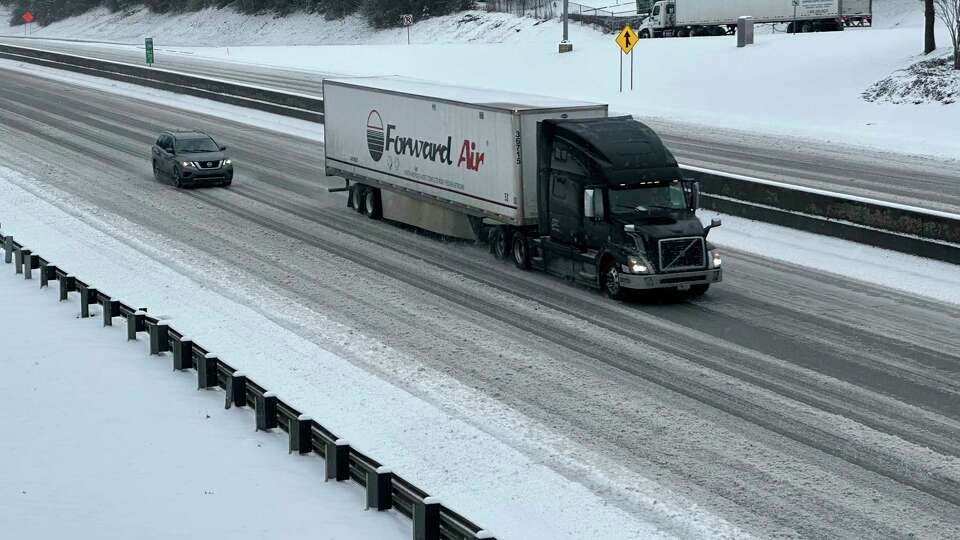 /// A truck picks its way along a slushy Interstate 285 northeast of downtown in Atlanta on Friday, Jan. 10, 2025.