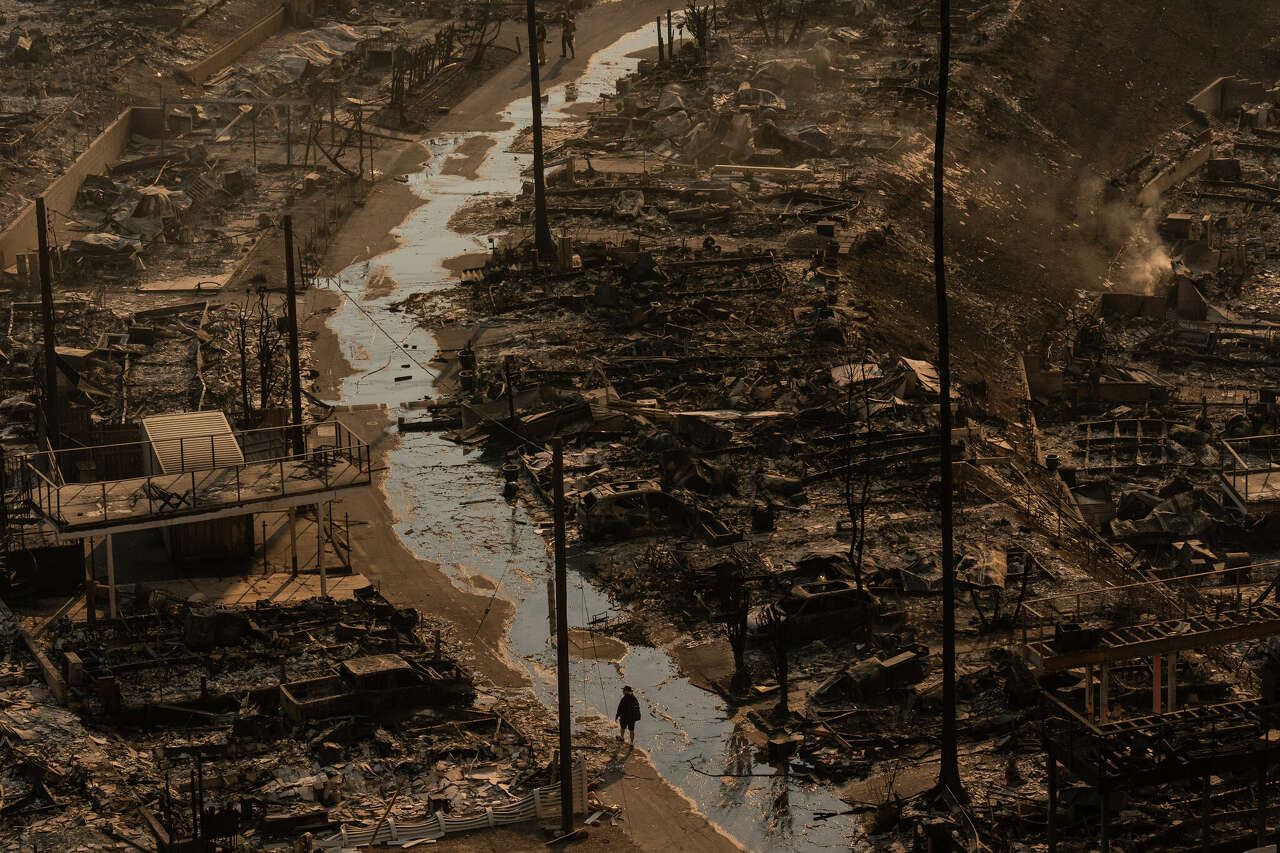 A person walks amid the destruction left behind by the Palisades Fire in the Pacific Palisades neighborhood of Los Angeles, Thursday, Jan. 9, 2025.