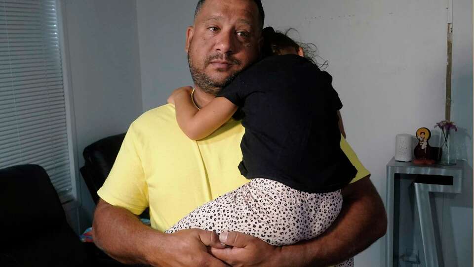 FILE - Venezuelan Victor Macedo holds his daughter Sonia at their home, in in Davie, Fla., Sept. 27, 2023. The family crossed the border U.S. almost two years ago. Since then, they have been living in South Florida with the support of family and friends. They recently qualified for temporary protected status.