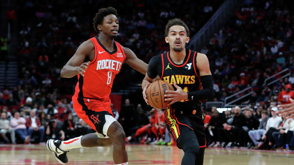 Atlanta Hawks guard Trae Young, right, drives in front of Houston Rockets forward Jae'Sean Tate during the first half of an NBA basketball game Wednesday, Dec. 20, 2023, in Houston. (AP Photo/Michael Wyke)