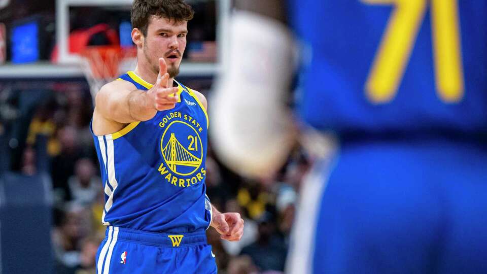 Golden State Warriors center Quinten Post (21) gestures to a teammate after scoring a 3-point basket during the second half of an NBA basketball game against the Indiana Pacers in Indianapolis, Friday, Jan. 10, 2025. (AP Photo/Doug McSchooler)