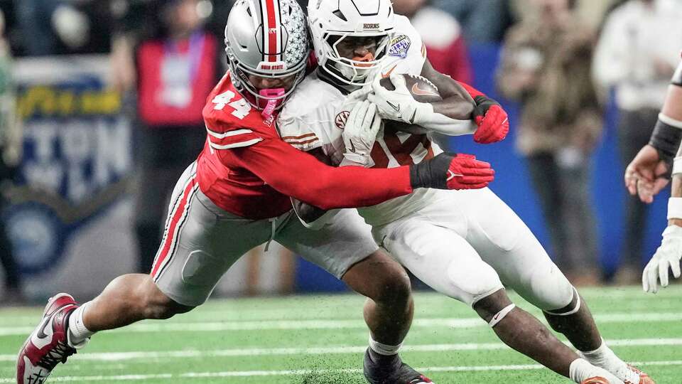 Texas running back Quintrevion Wisner (26) is stopped by Ohio State defensive end JT Tuimoloau (44) during the second half of a College Football Playoff semifinal game at the Goodyear Cotton Bowl, Friday, Jan. 10, 2025, in Arlington.